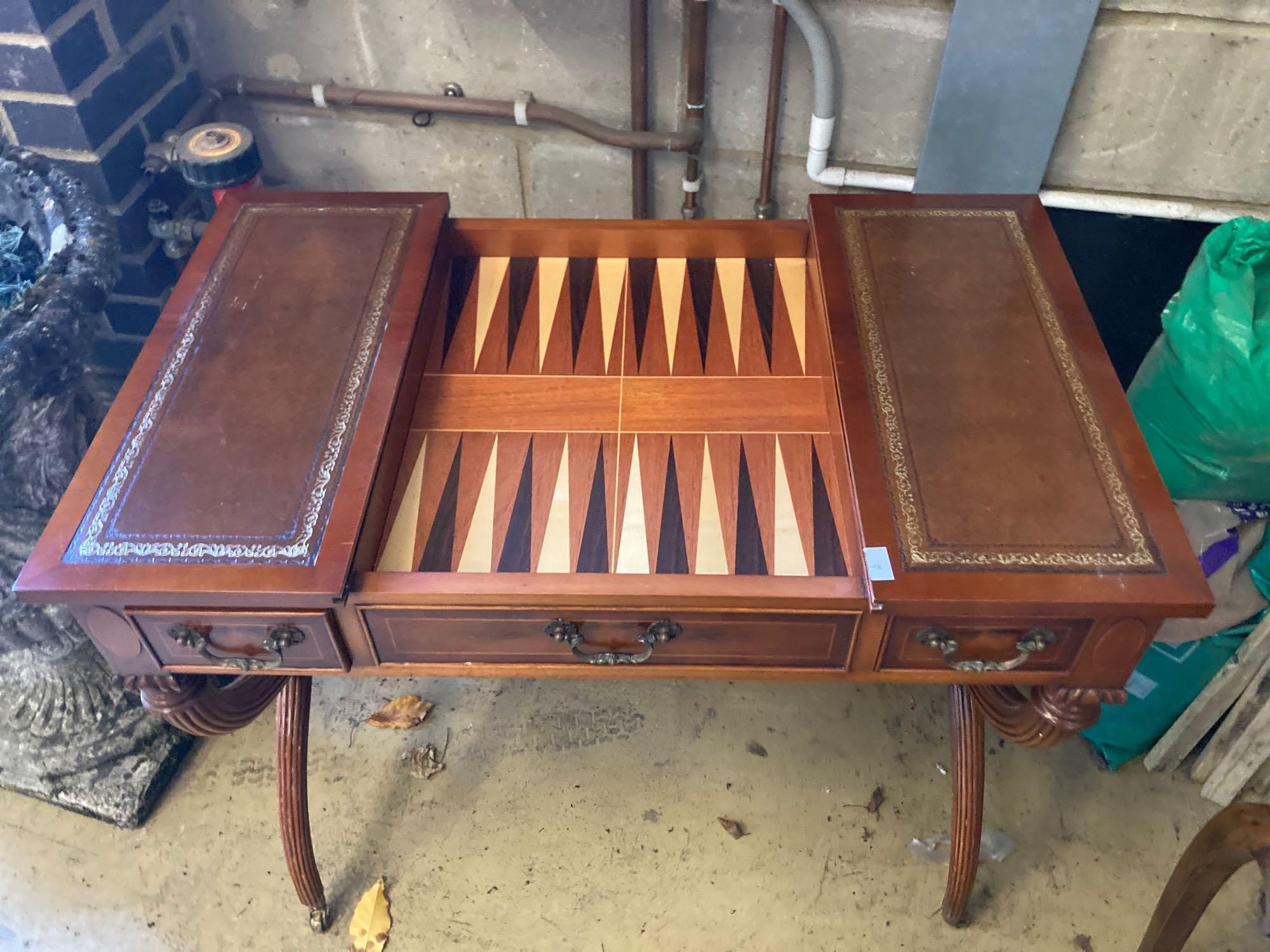 A modern yew wood and mahogany writing table, with sliding backgammon and chessboard top, width 92cm